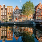 1495422795
Old historic Dutch houses reflecting in the canal on a sunny day, Amsterdam, Netherlands - stock photo