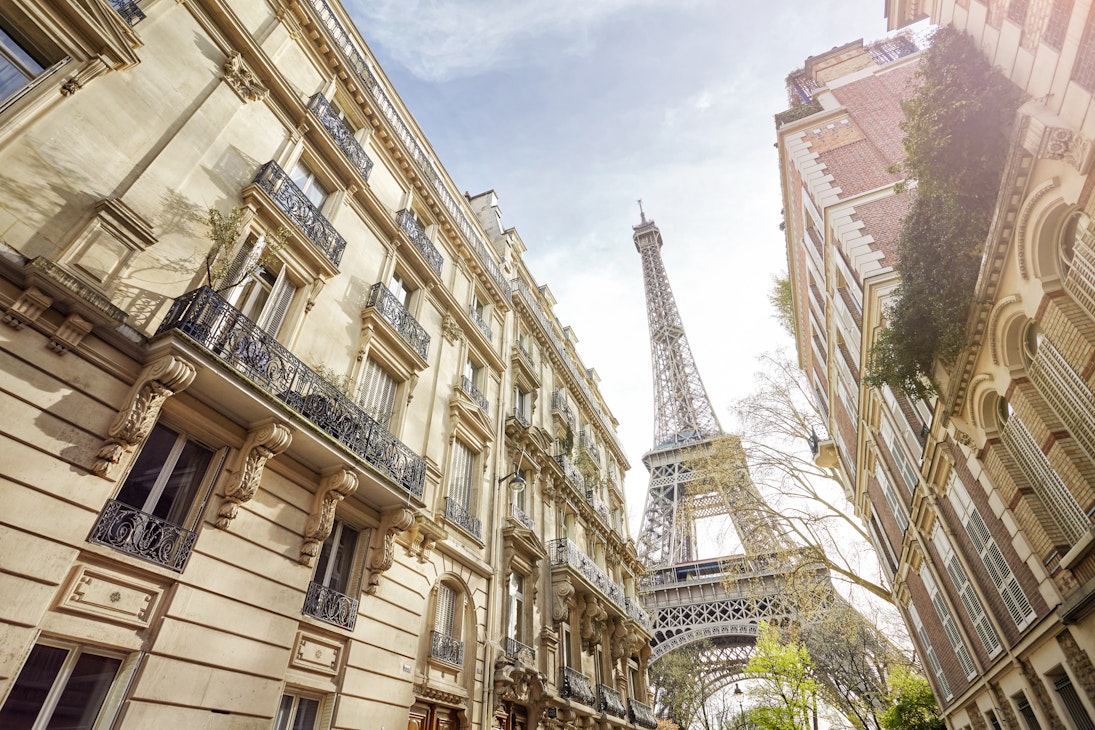 Low-angle view of the Eiffel Tower, as seen from a Paris street.